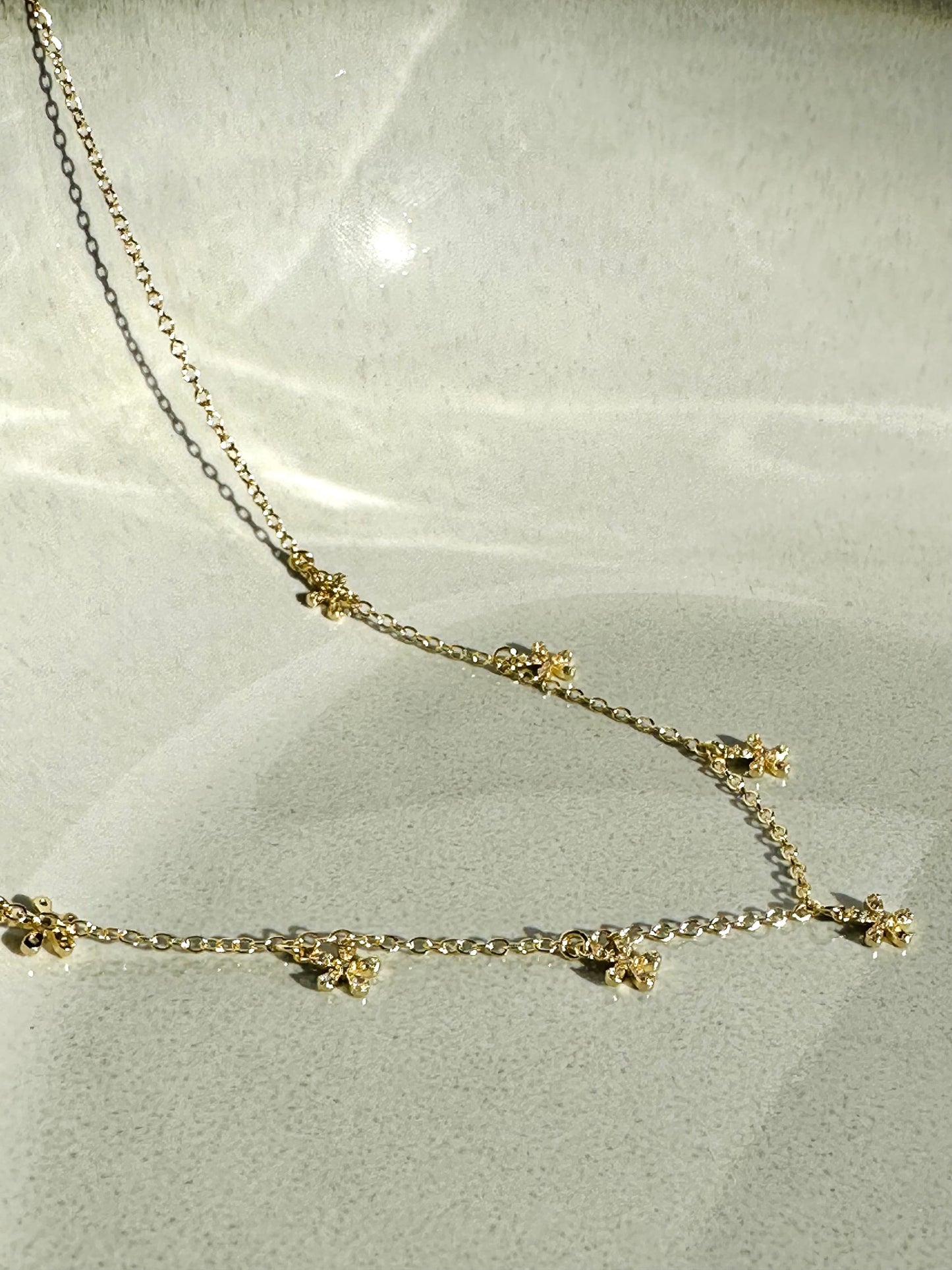 Collana artigianale in argento galvanizzato oro con ciondoli a fiore e zirconi